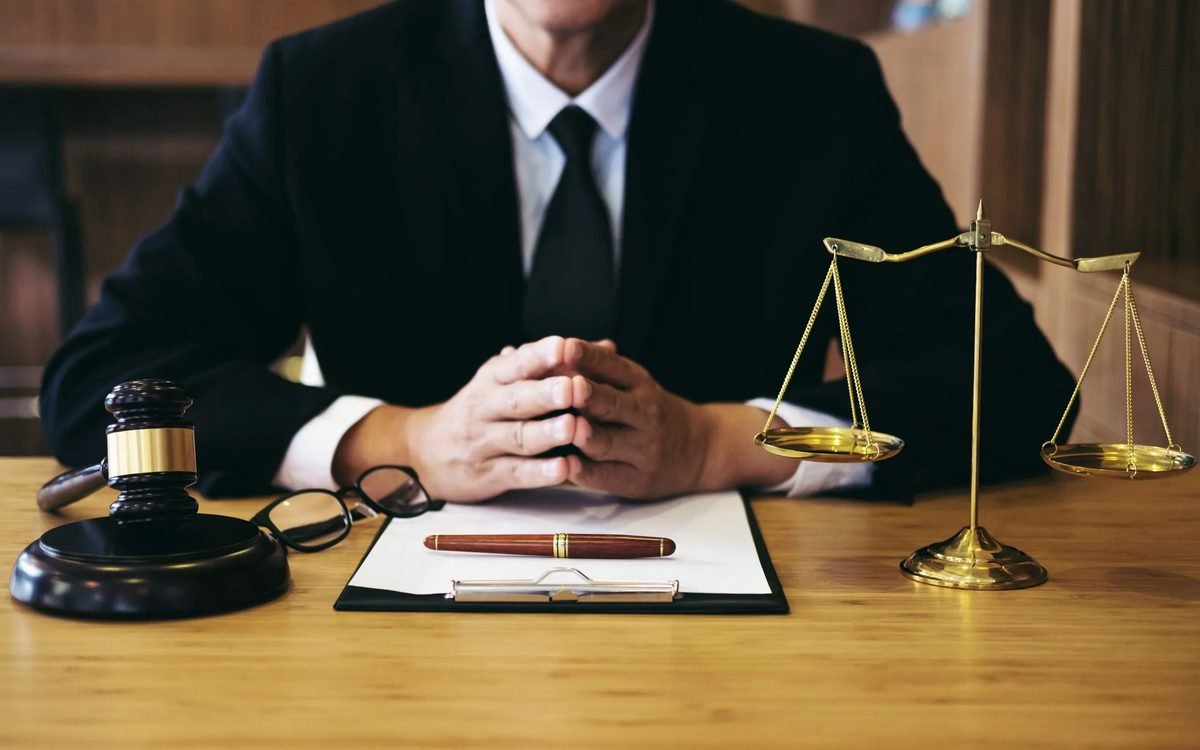 Attorney at a desk with a gavel, scales of justice, and case documents